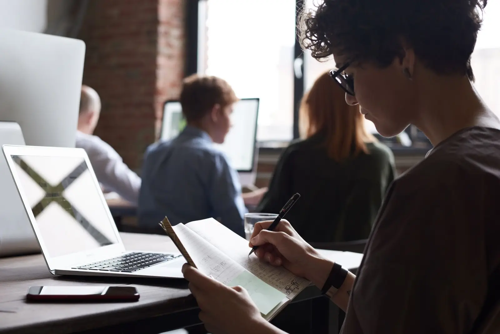 Professionals working together at laptops in a shared office