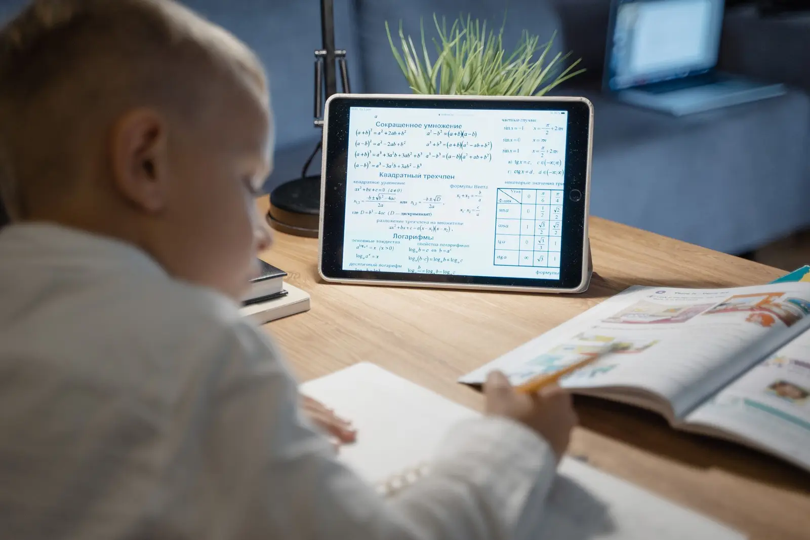A boy working through math problems on a tablet at a desk