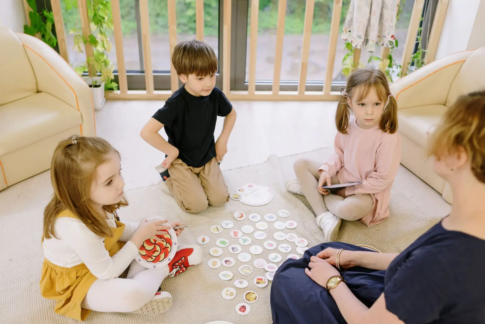 Young children playing a picture game on the floor with an adult