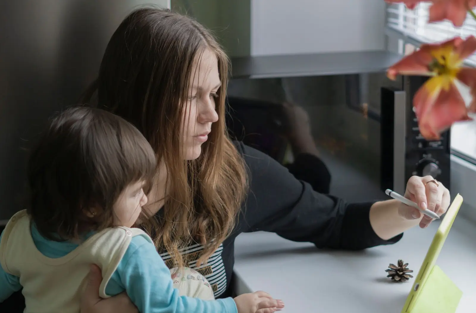 A mother and her young daughter looking at a tablet together