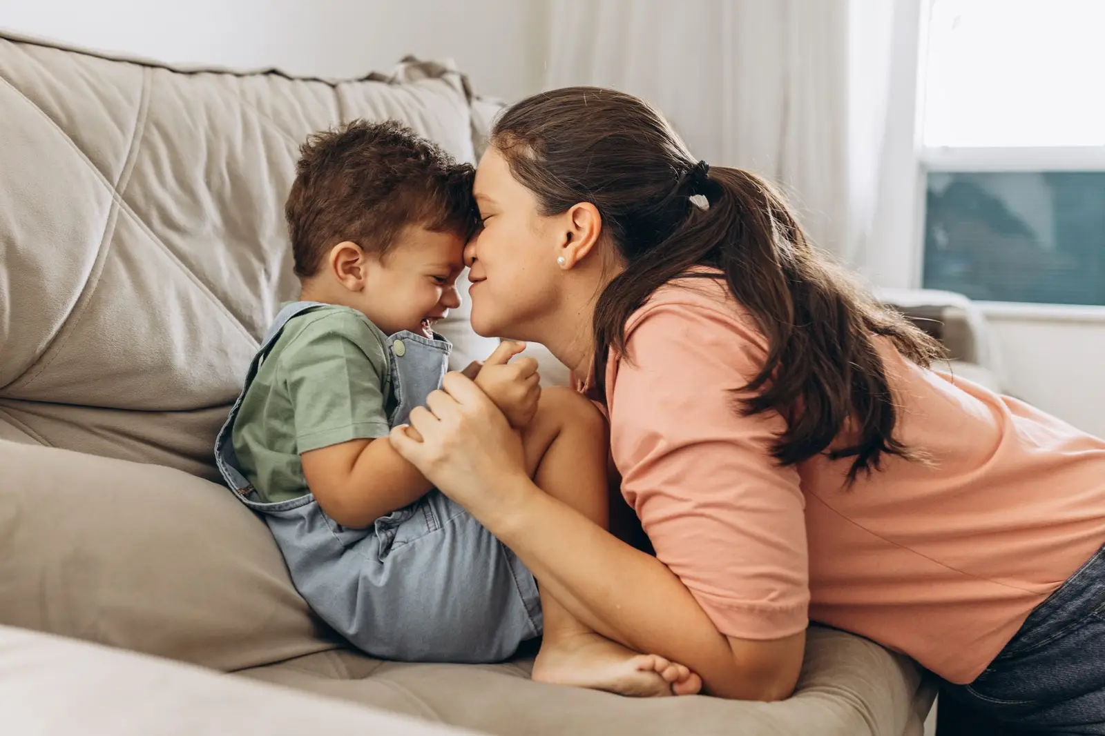 A mother and her young son sharing a close moment on the sofa