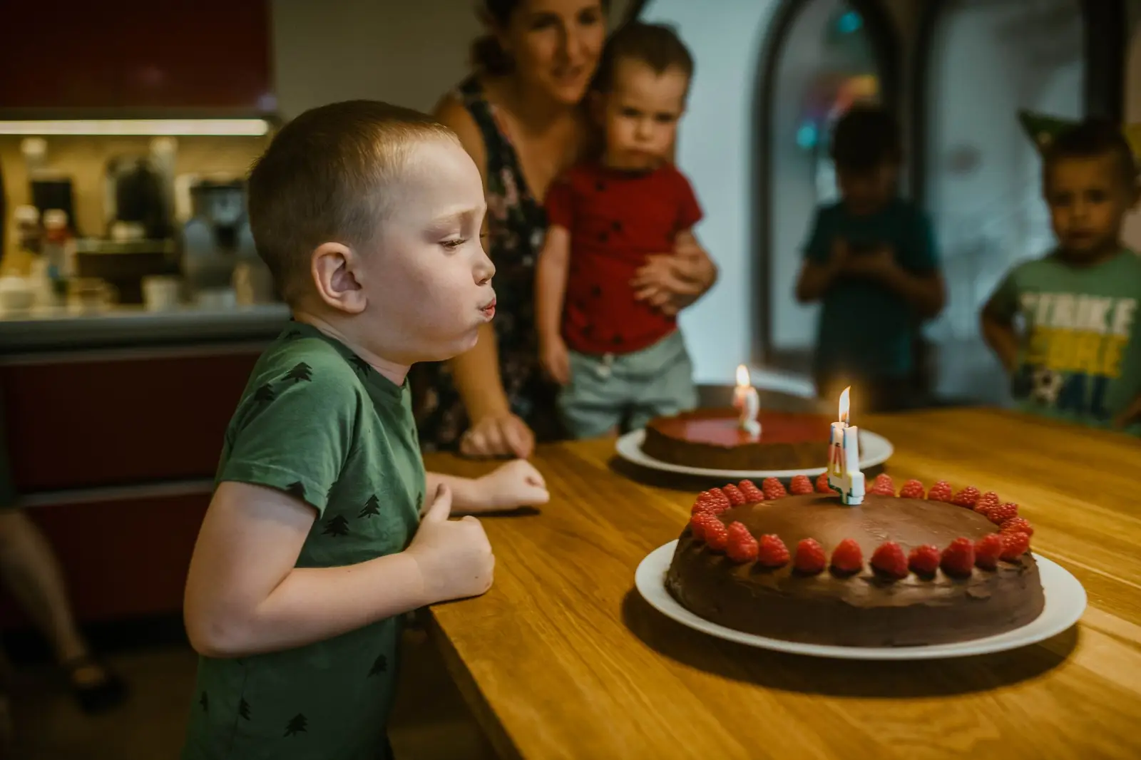 A boy blowing out candles on a birthday cake