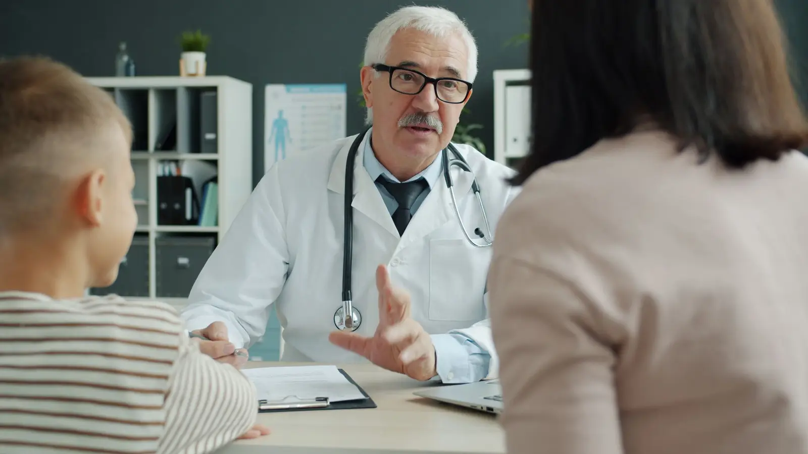A doctor talking with a parent and child during an appointment