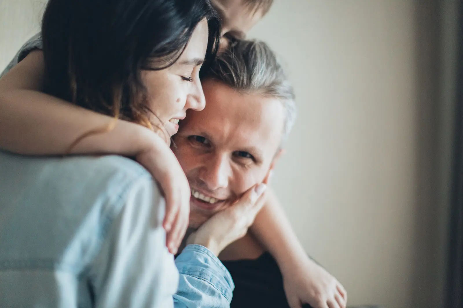 A smiling couple sharing a hug at home