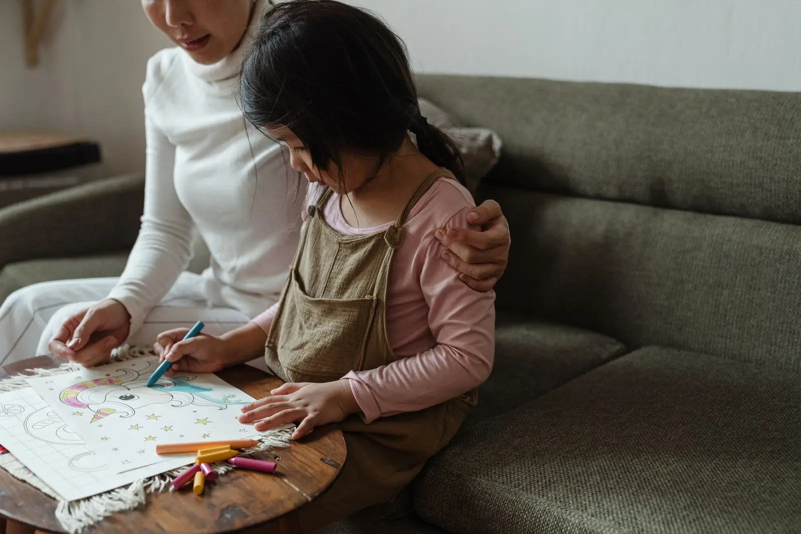 A woman and a young girl colouring together at a low table