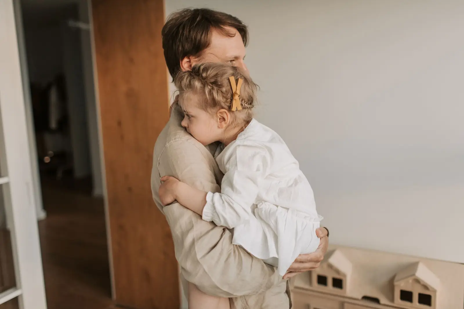 A father holding his young daughter close in a calm hug