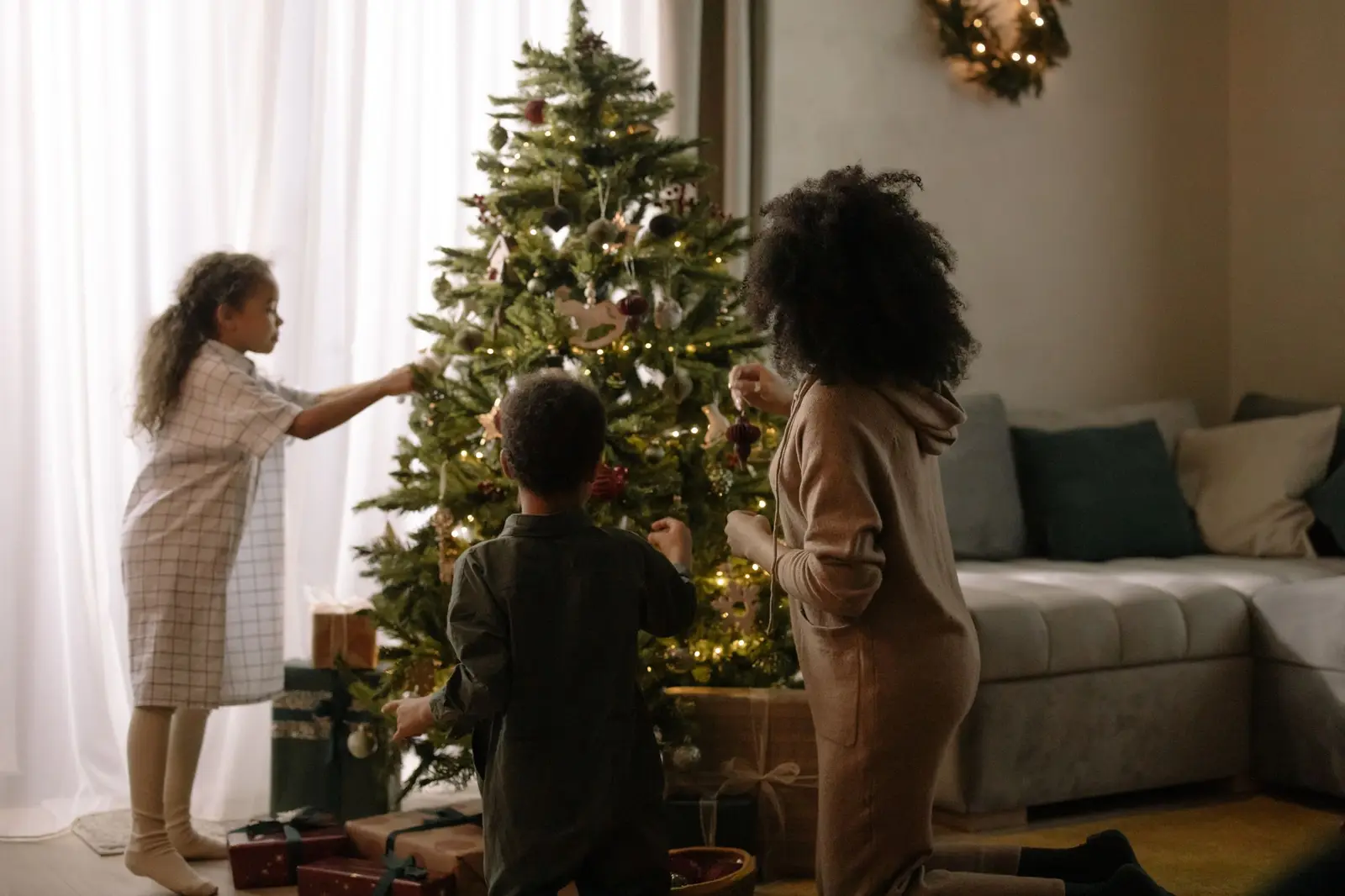 A family decorating a Christmas tree in their living room