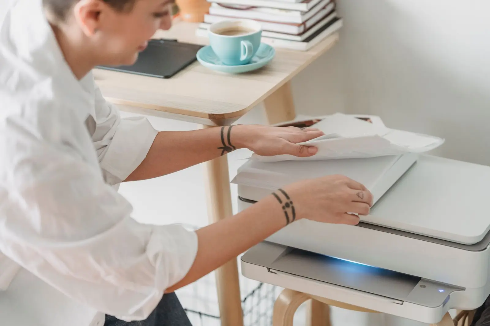 A person taking printed sheets from a home printer