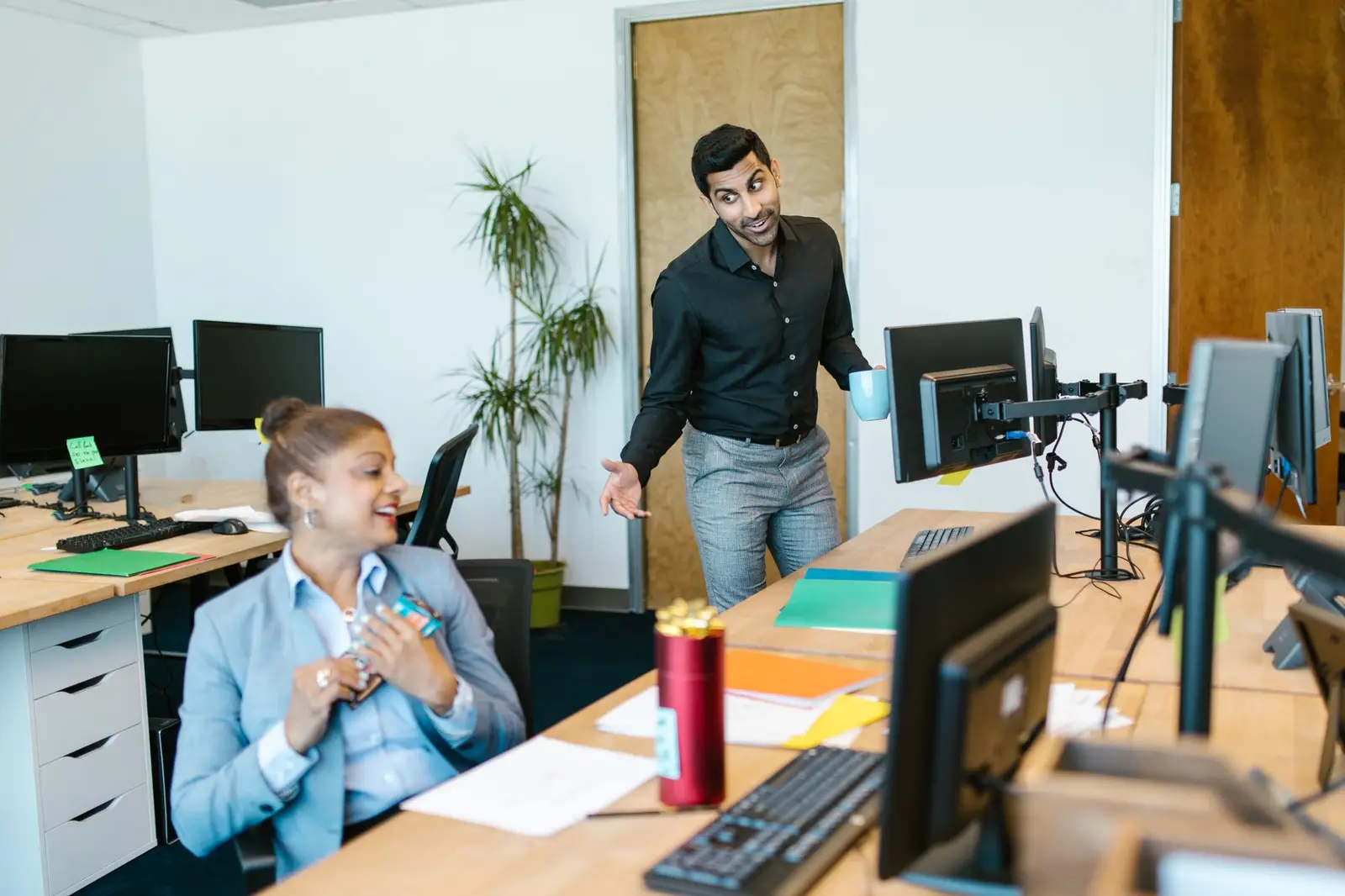 Two colleagues having a cheerful conversation in an office