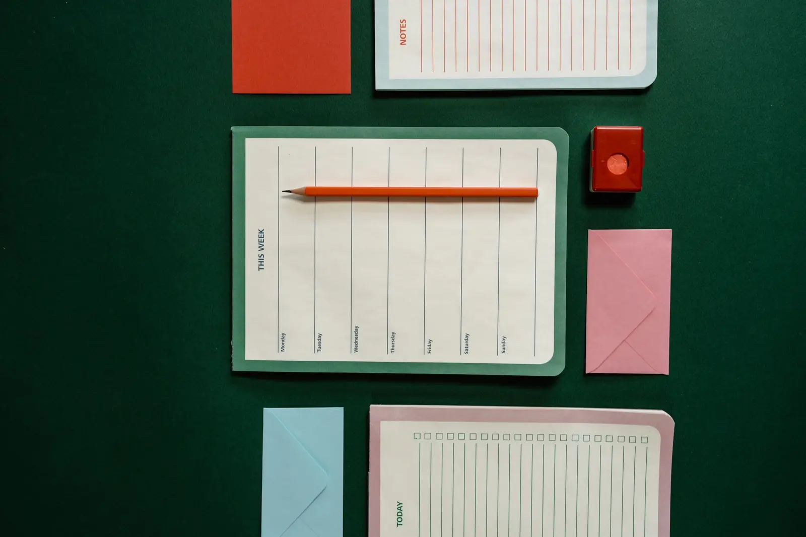 Planners, envelopes, a pencil and note cards laid out on a table