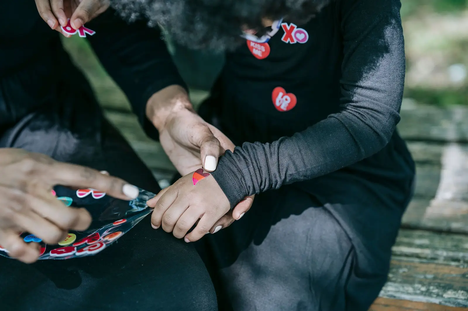 Hands peeling stickers and sticking them on clothing