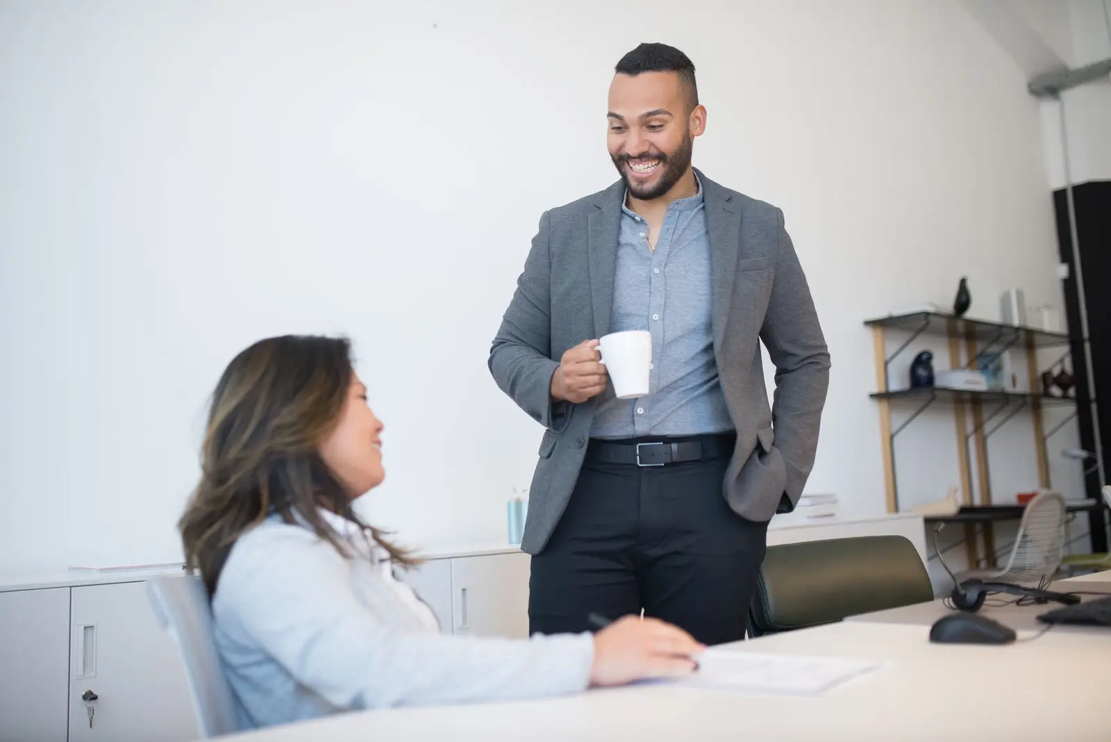 Two colleagues smiling and talking in a bright office