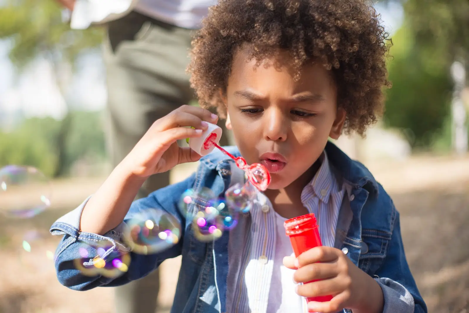 A boy blowing bubbles outdoors